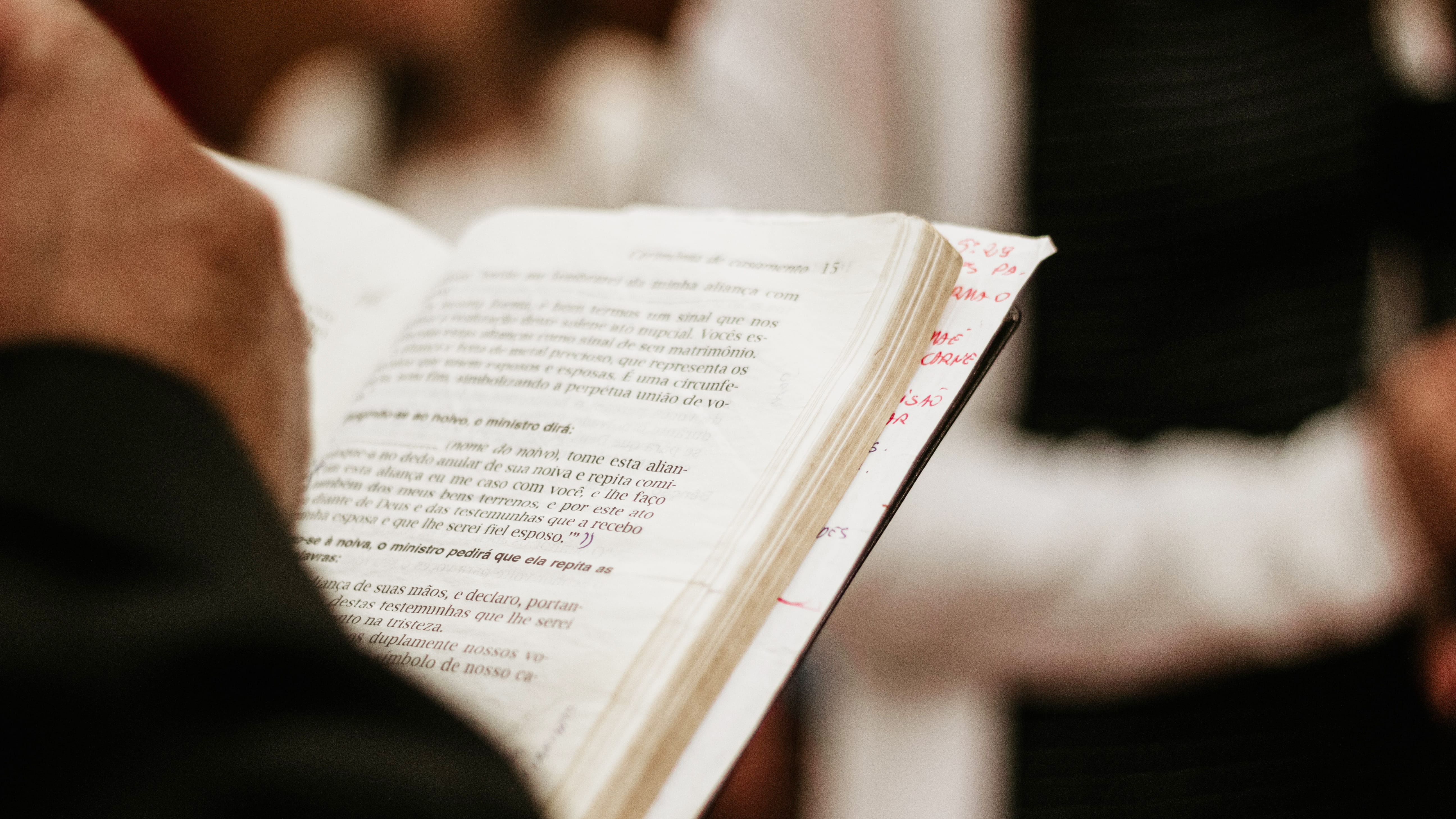 Closeup of pastor using a Spanish-language Bible during worship. Photo by Nicolas Rizzon on Unsplash.